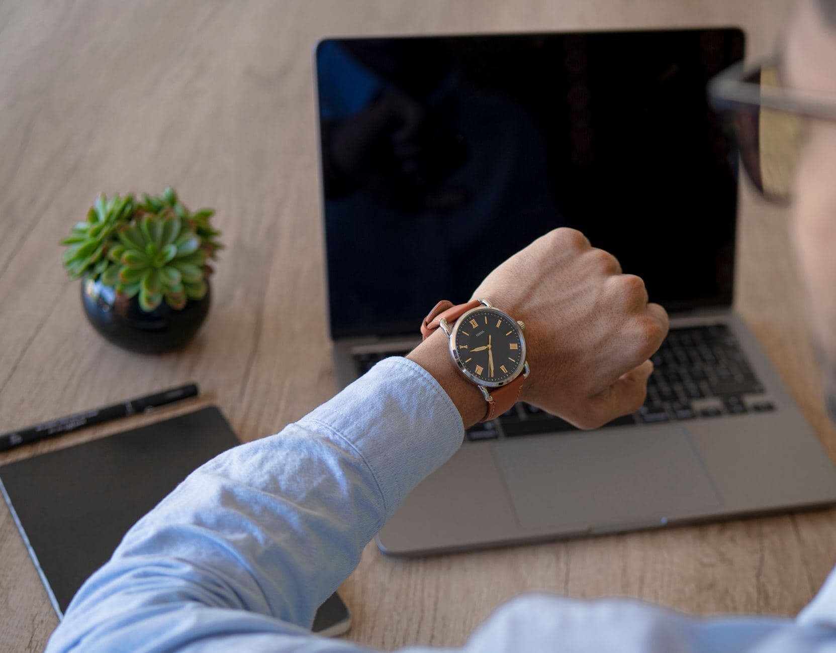 Wristwatch and notebook on a desk