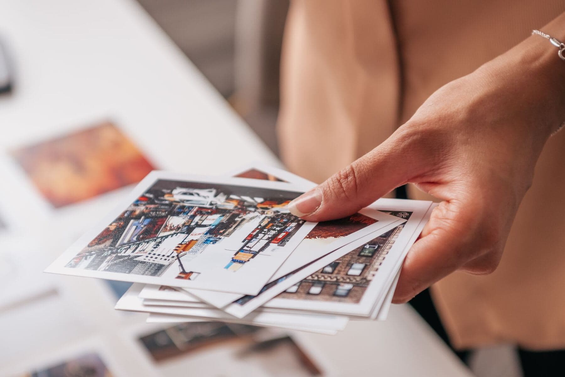 Hands arranging photo prints into a board layout