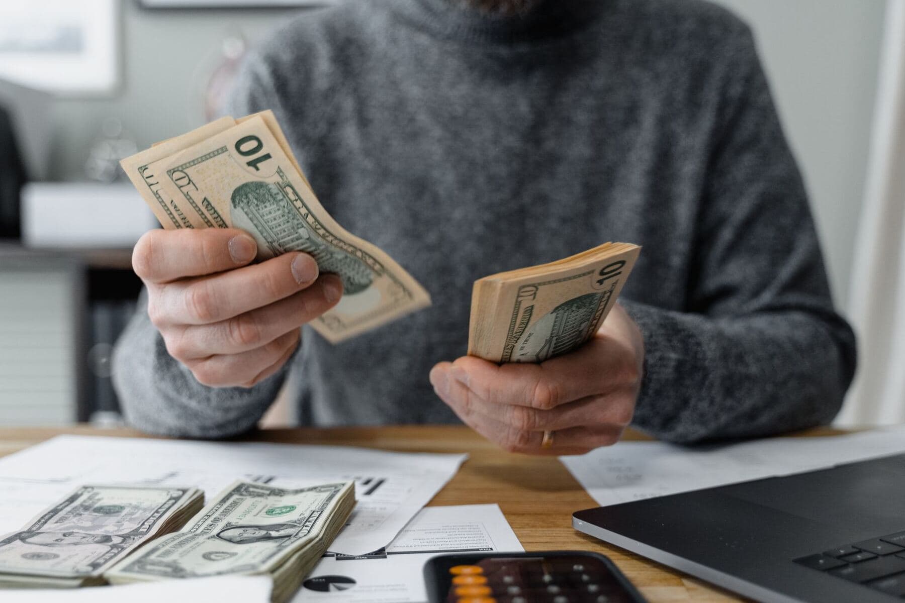 Person counting money at a desk