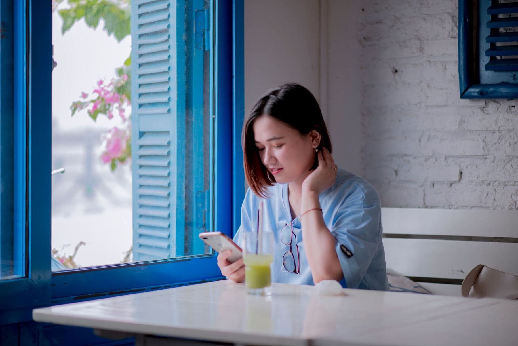 Person using a phone by a window