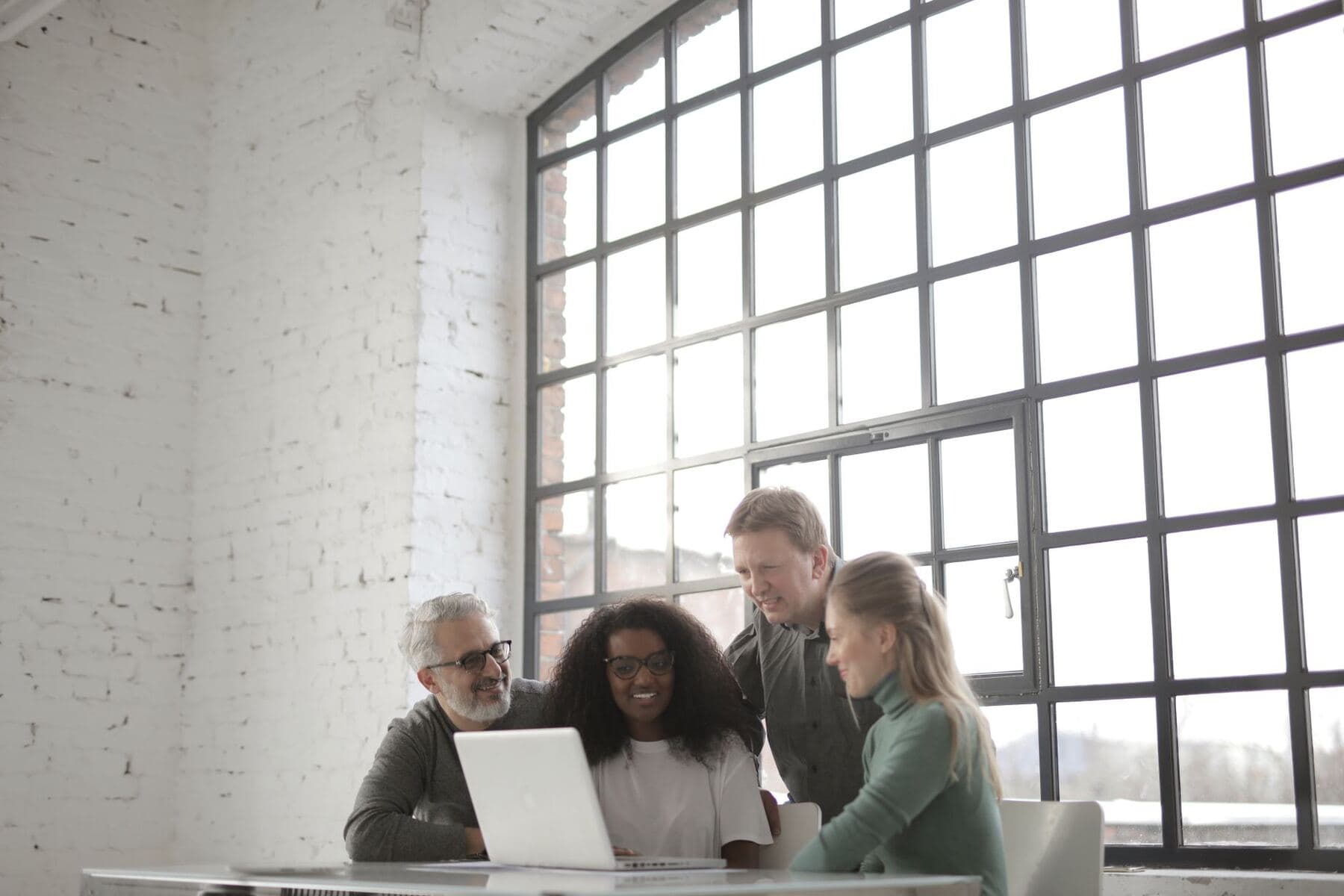 Team meeting around a laptop