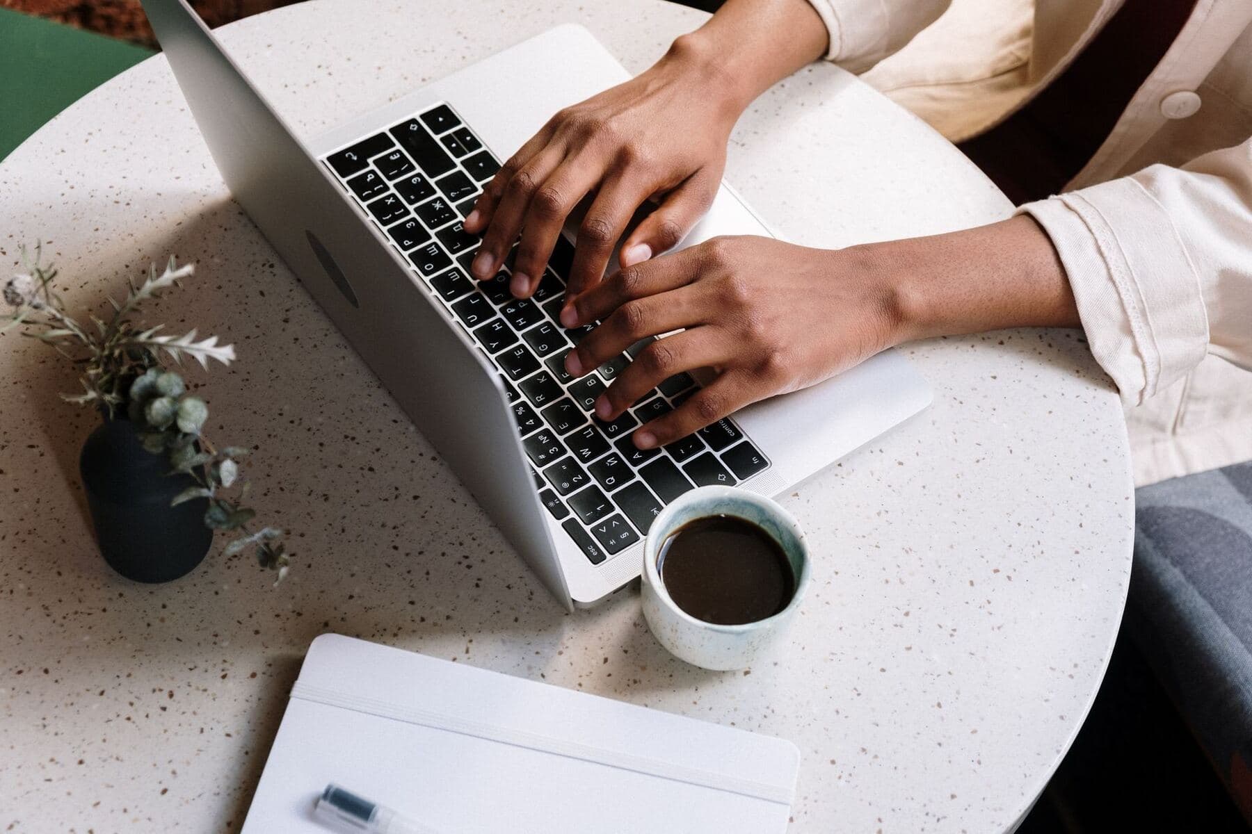 Blogger writing at a laptop with coffee