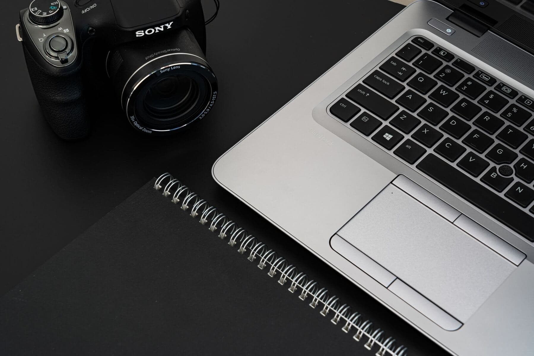 Desk with a notebook and camera used for blog content production