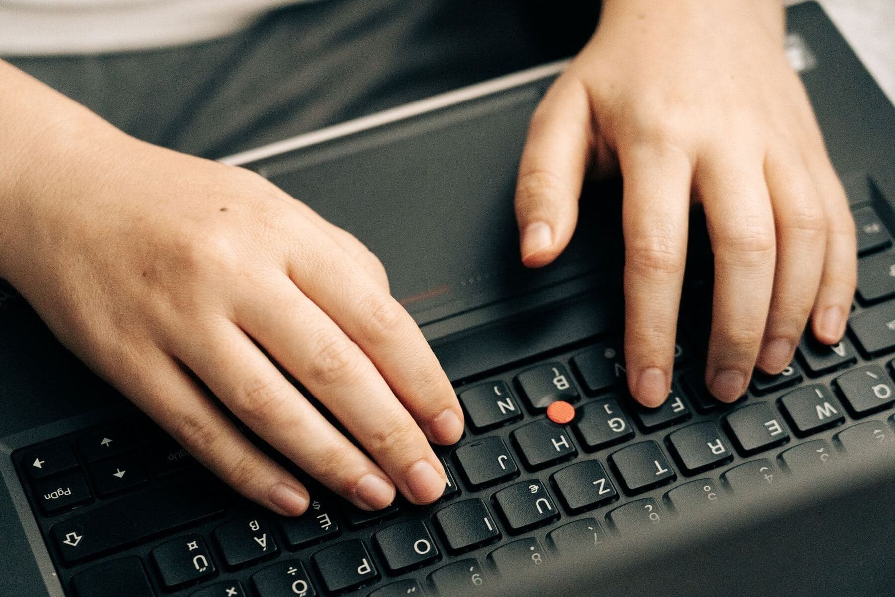 Person typing on a laptop keyboard