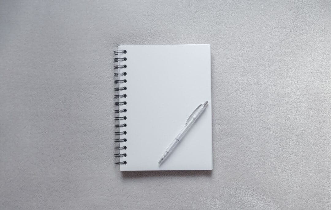 Notebook and pen used to record a Pinterest keyword research worksheet
