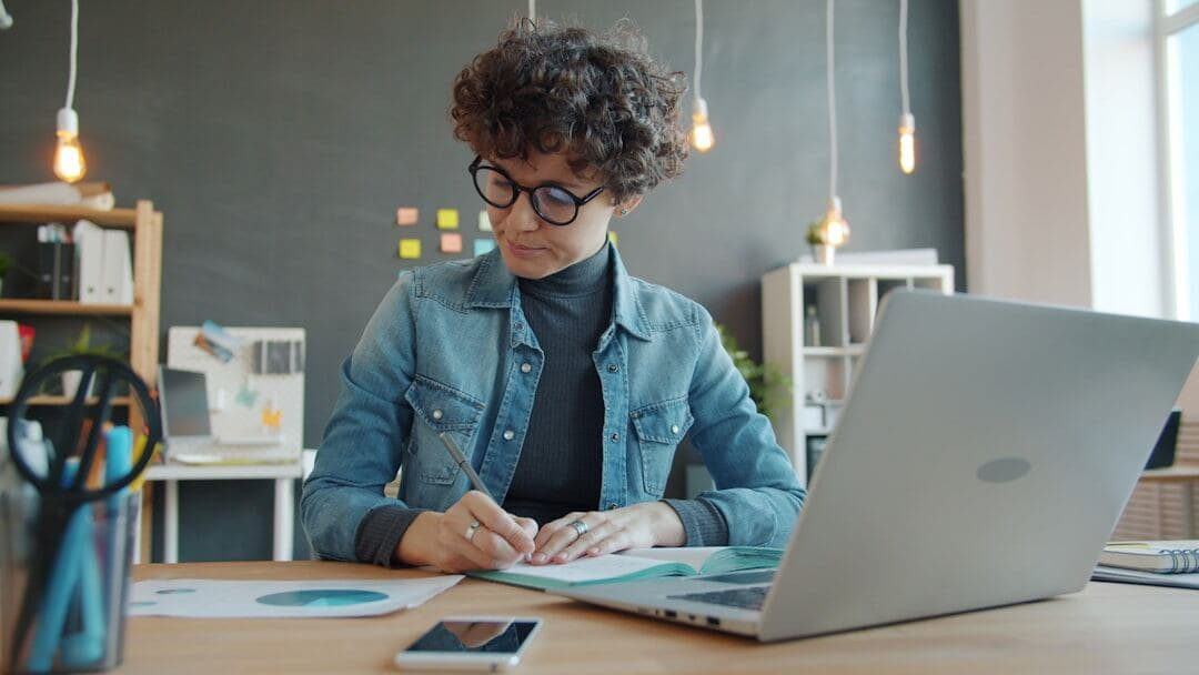 Designer sketching several different pin concepts for one blog post at a laptop